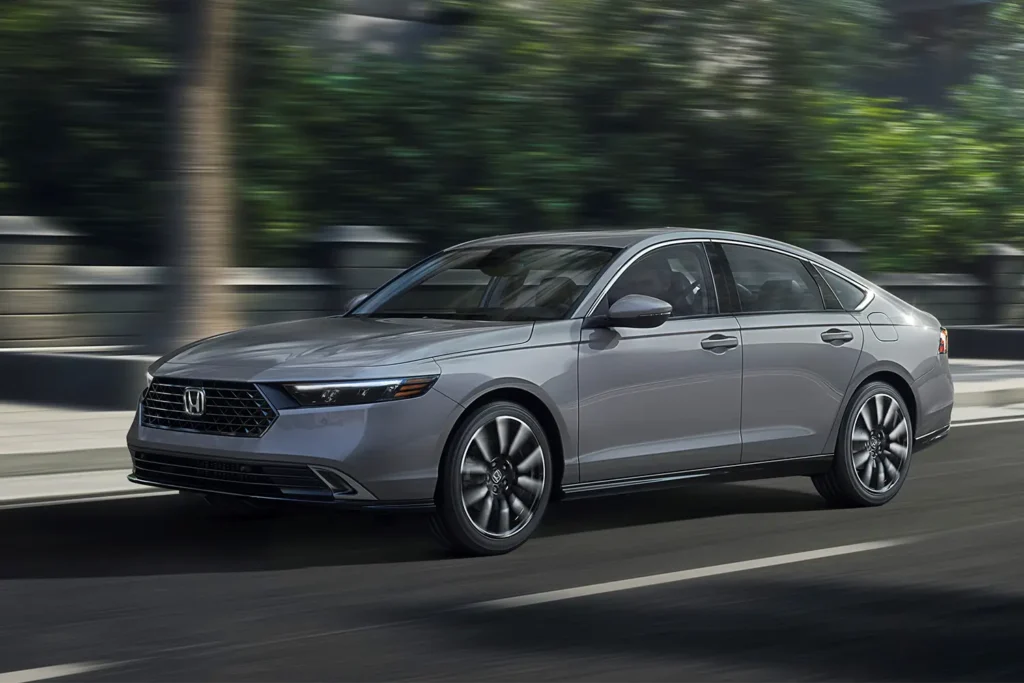Honda Accord Touring sedan driving on the road, front three-quarter view.