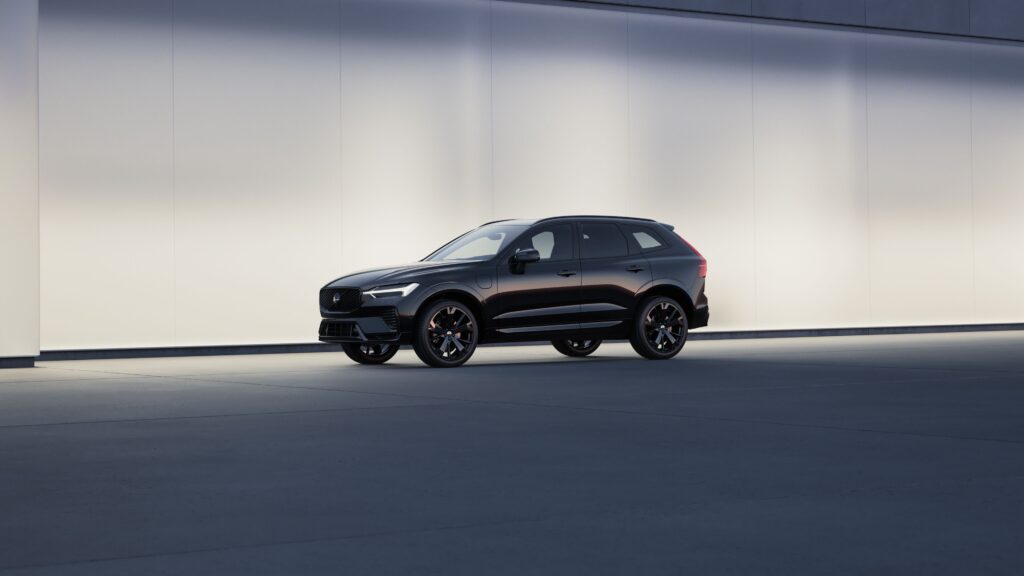 Black Volvo XC60 luxury SUV shown in side profile against a clean modern wall for a Volvo XC60 Review.