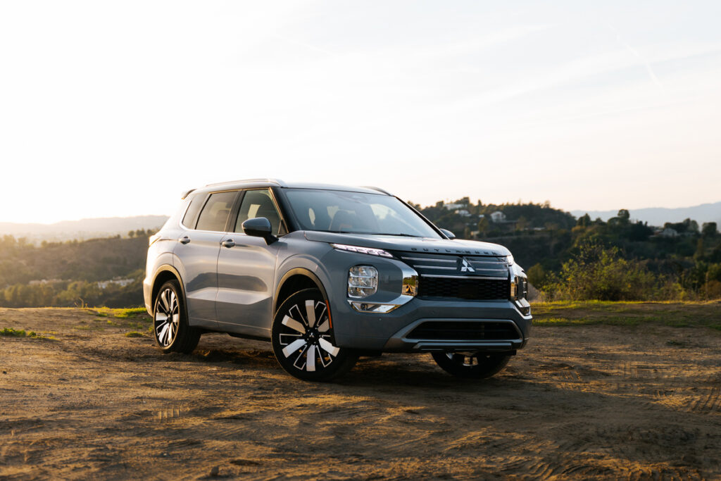 Silver Mitsubishi Outlander SUV parked on a dirt overlook at sunset for a Mitsubishi Outlander Review.