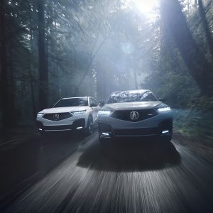 Acura MDX Review image of two 2026 Acura MDX SUVs driving on a forest road