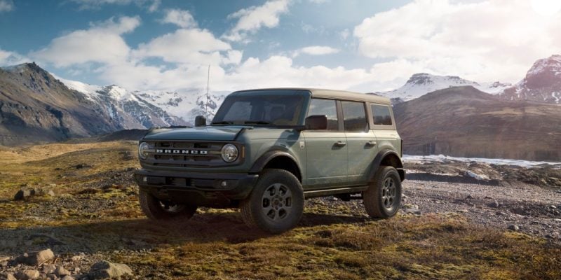 Green Ford Bronco parked in a rugged mountain landscape, featured in our Ford Bronco Review.