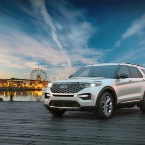 White Ford Explorer parked on a waterfront boardwalk at dusk, featured in our Ford Explorer Review.