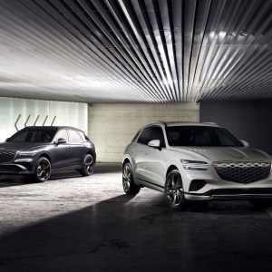 Two Genesis GV70 luxury SUVs shown in a modern indoor garage setting for a Genesis GV70 Review.