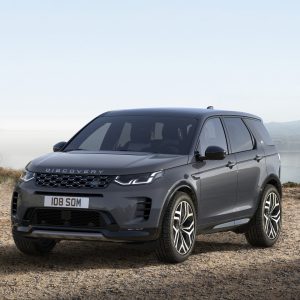 Gray Land Rover Discovery SUV parked on a gravel overlook with mountains and a lake in the background for a Land Rover Discovery Review.