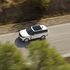 White Range Rover luxury SUV driving on a paved road in an overhead view for a Range Rover Review.