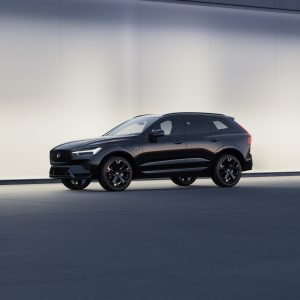 Black Volvo XC60 luxury SUV shown in side profile against a clean modern wall for a Volvo XC60 Review.
