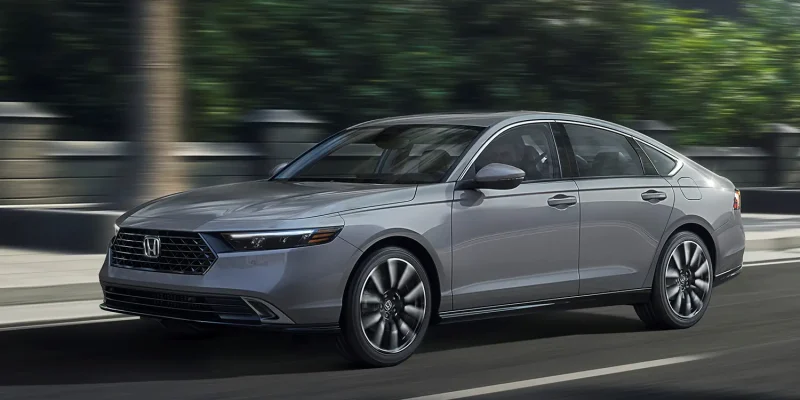 Honda Accord Touring sedan driving on the road, front three-quarter view.